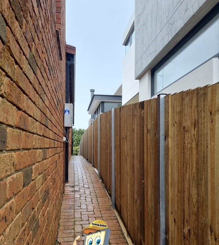 Treated pine timber fence built along a narrow brick paved laneway at a Sydney property