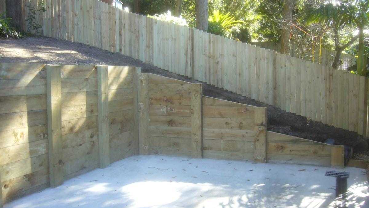 Treated pine timber sleeper retaining wall holding back soil to create a level area at a Sydney property