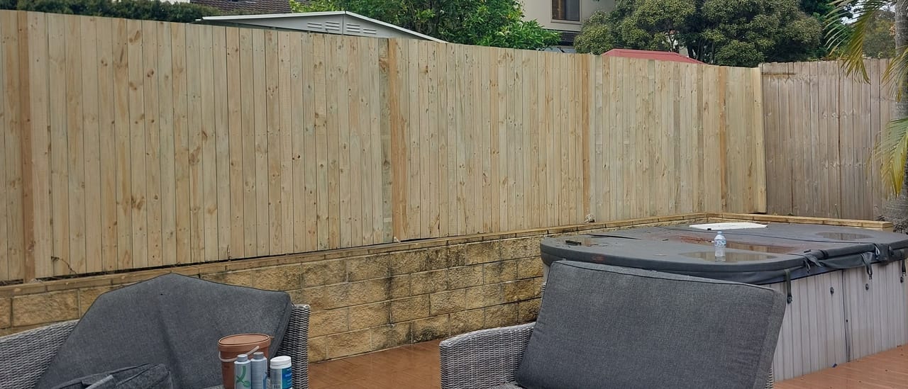 Treated pine timber fence enclosing a paved outdoor living area with lounge seating at a Sydney home