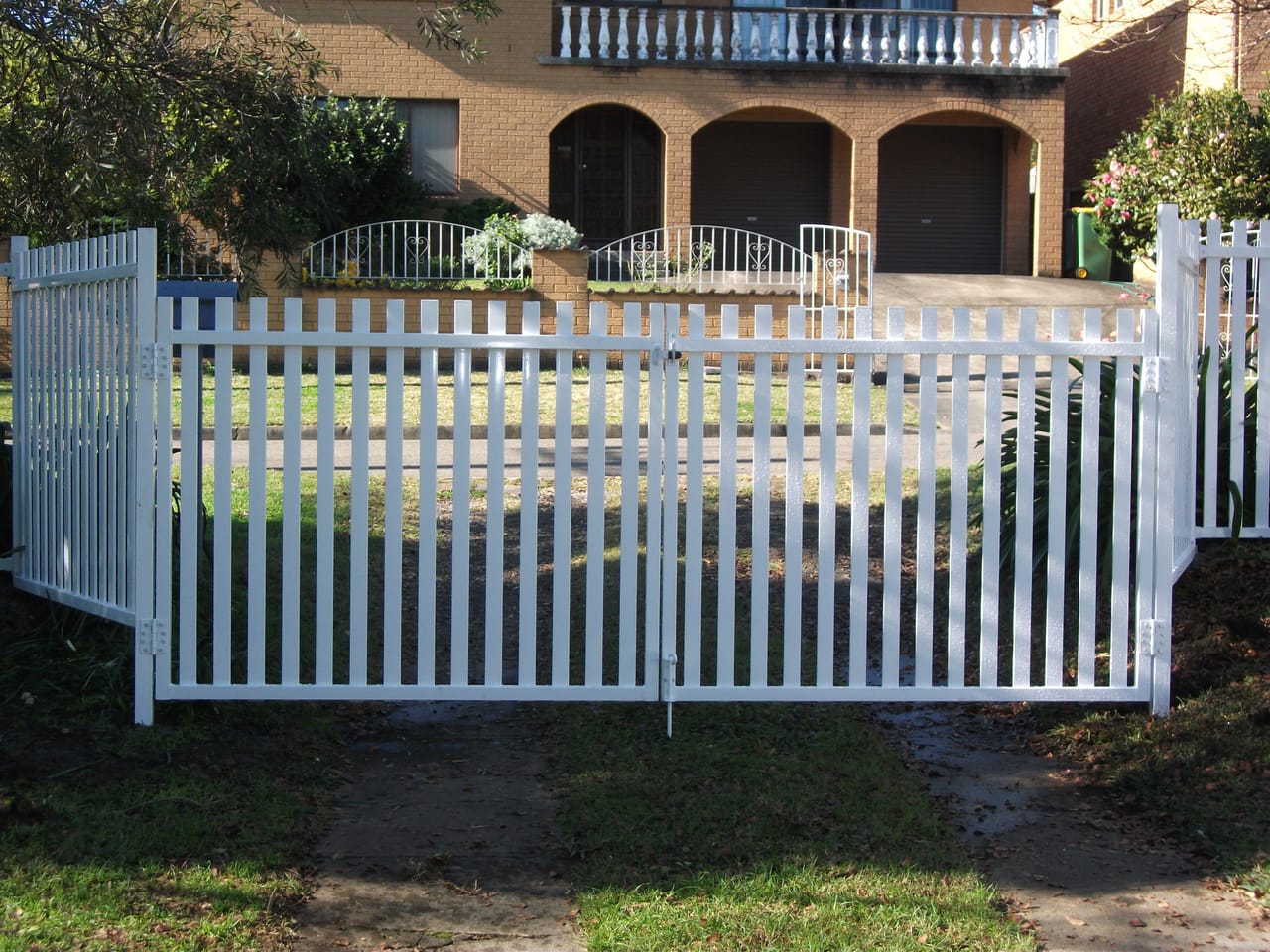 White painted timber picket double gates installed at the driveway entrance of a Sydney home